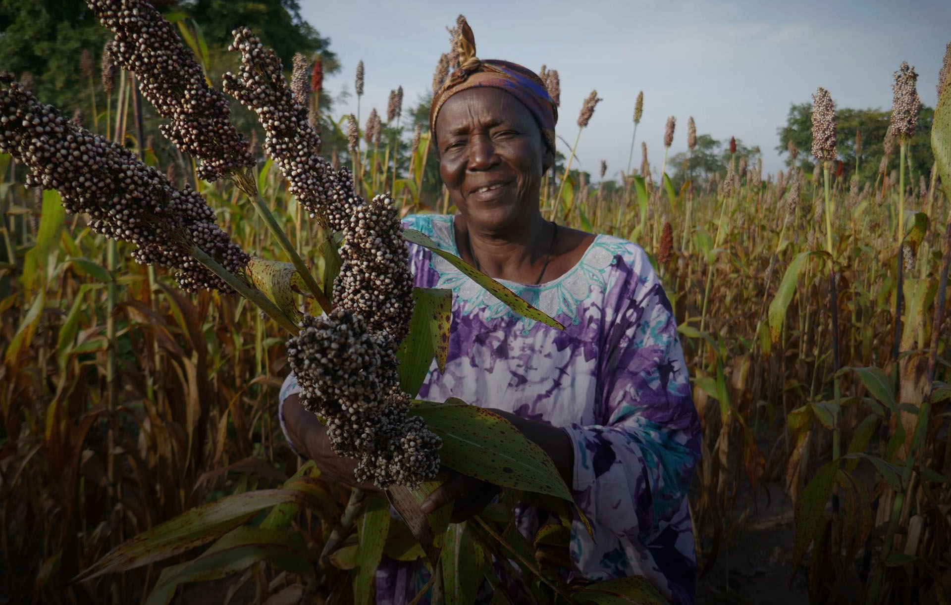 Dialoger*in bei Corris: Eine Frau freut sich über ihre Ernte